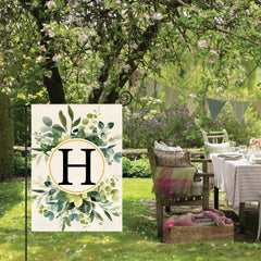 AVOIN Monogram H Floral Garden Flag displayed on a stand