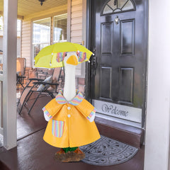 Goose statue wearing the Arrowbash raincoat in a garden setting