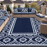 HUGEAR 9' x 12' navy blue outdoor rug laid out in a patio setting