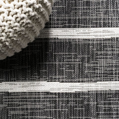 JONATHAN Y Berber Stripe Round Area Rug displayed on patio