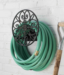 Liberty Garden Hose Butler mounted on wall with garden hose