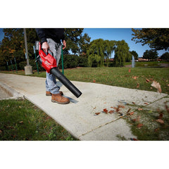 Milwaukee M18 FUEL Handheld Blower in use clearing leaves