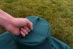 Mini Lustrous Grill Cover laid on a Medium Big Green Egg Grill