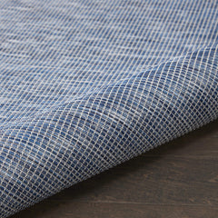 Nourison Positano Navy Blue outdoor rug layered with patterned rugs