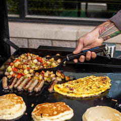 PIT BOSS Griddle Grub Shovel on a griddle with burgers and hashbrowns