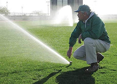 Rain Bird Rotor Pull-Up Tool in use adjusting a sprinkler nozzle