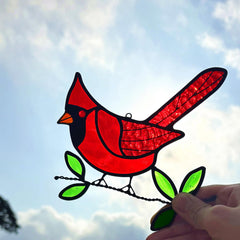 Red cardinal suncatcher hanging in a window
