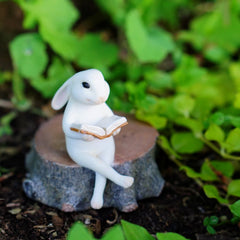 Side view of Top Collection Bunny Reading Statue on stump