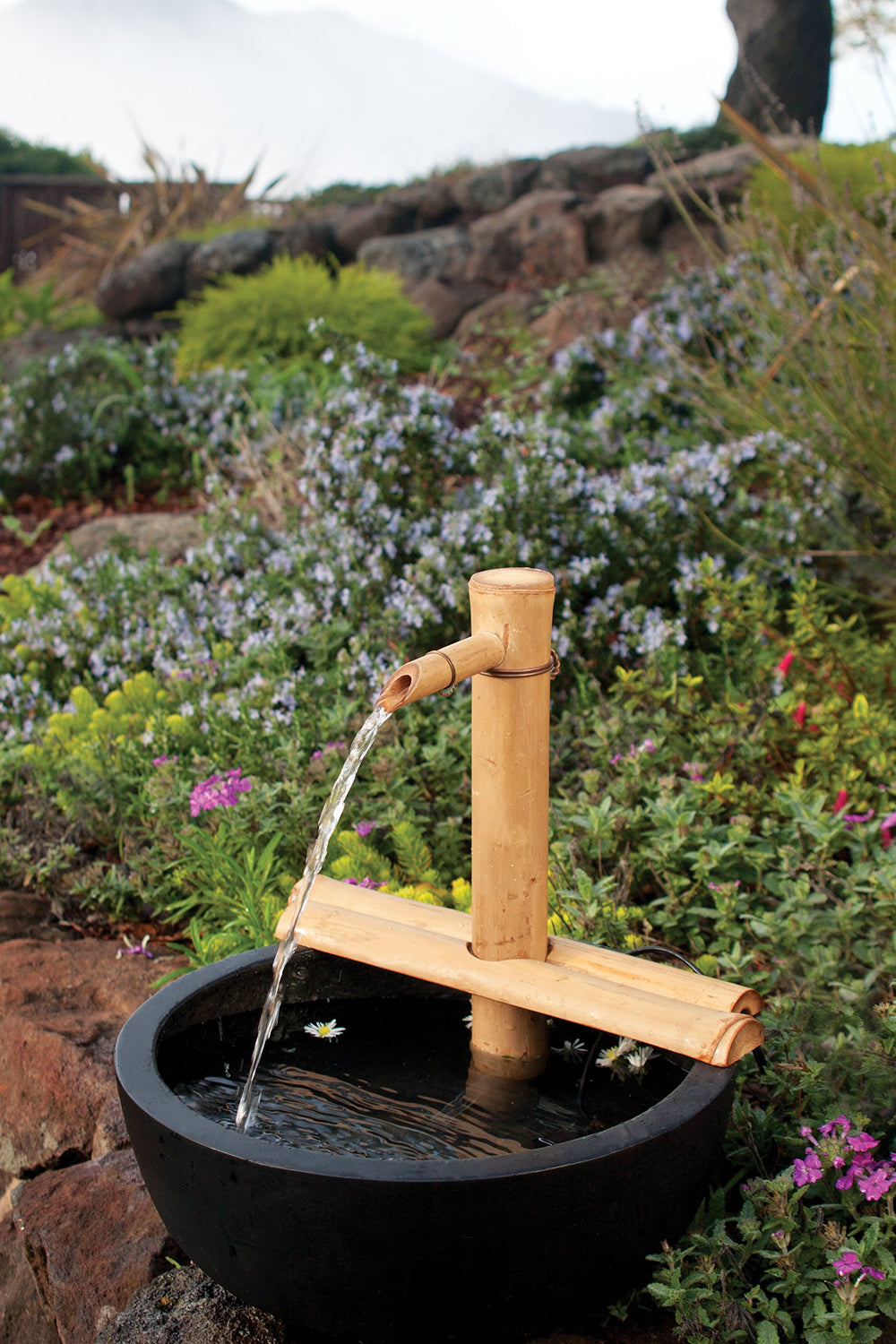 Adjustable bamboo fountain setup in a garden