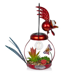 Alpine Solar Rooster in flower bed with warm glow