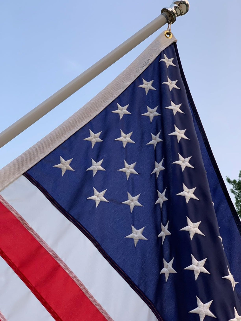 AOTAI American Flag 5x8 FT against a blue sky background
