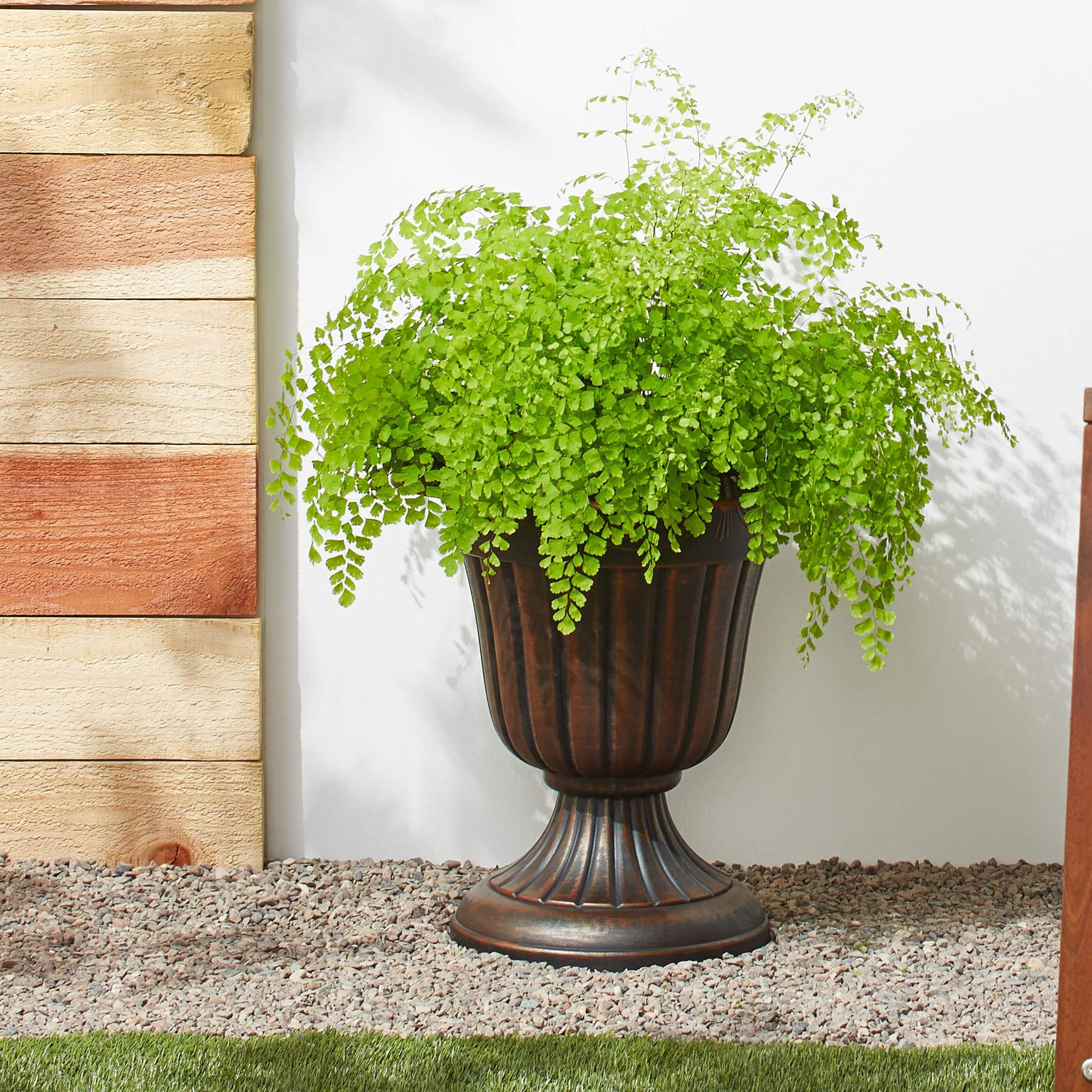 Arcadia Garden Products Urn Planter outdoors with flowers