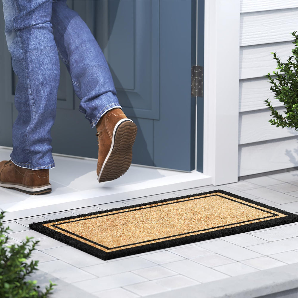 Barnyard Designs Border Welcome Mat on a stone porch