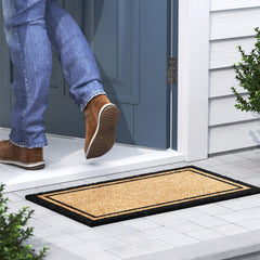 Barnyard Designs Border Welcome Mat on a stone porch