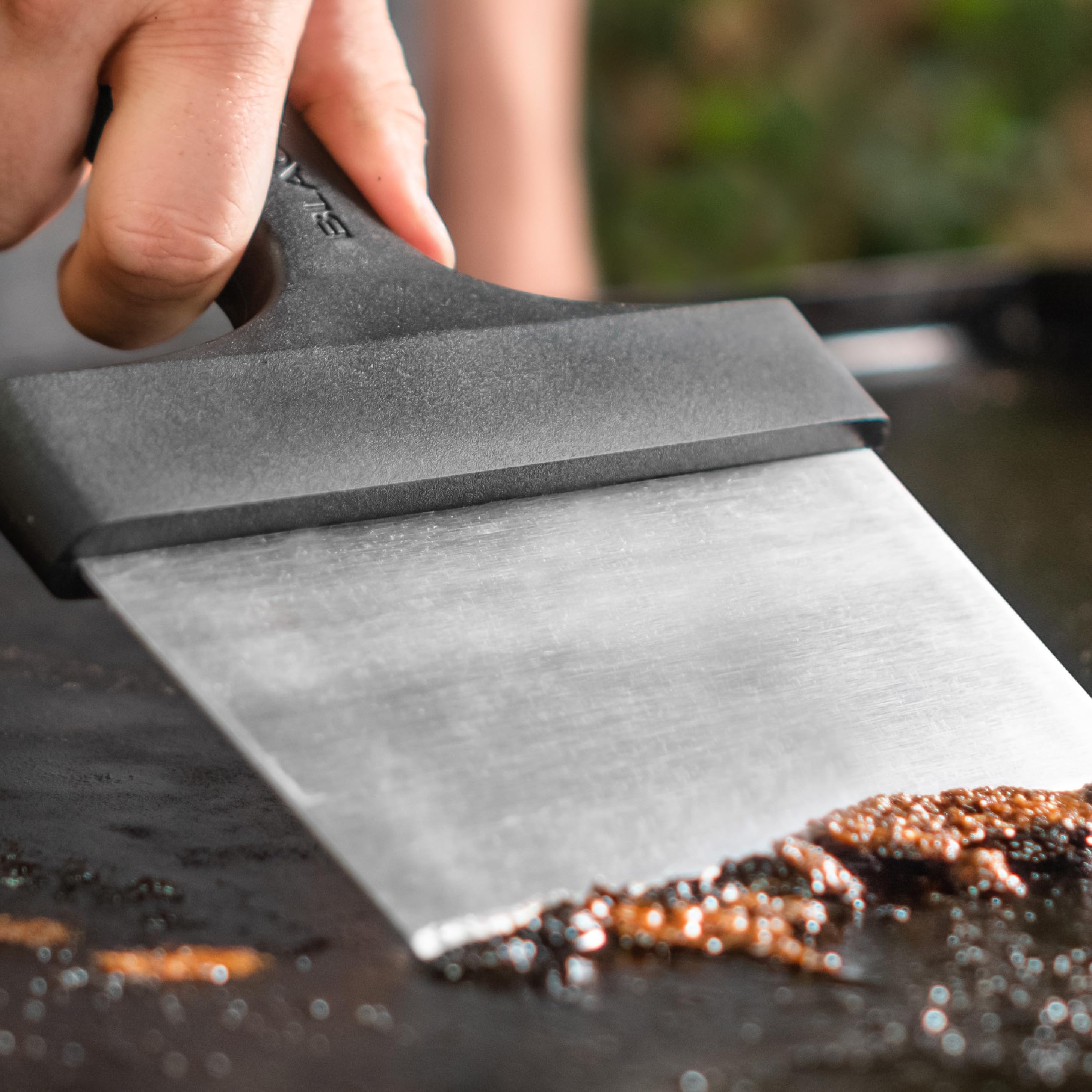 BLACKSTONE Griddle Scraper in use on a griddle