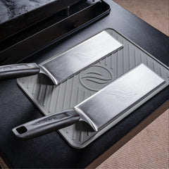 BLACKSTONE spatula mat resting on a grill shelf with tools