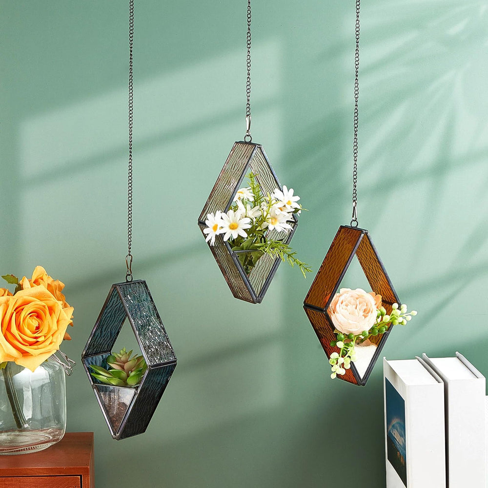 Blue and brown stained glass terrariums hanging on a window