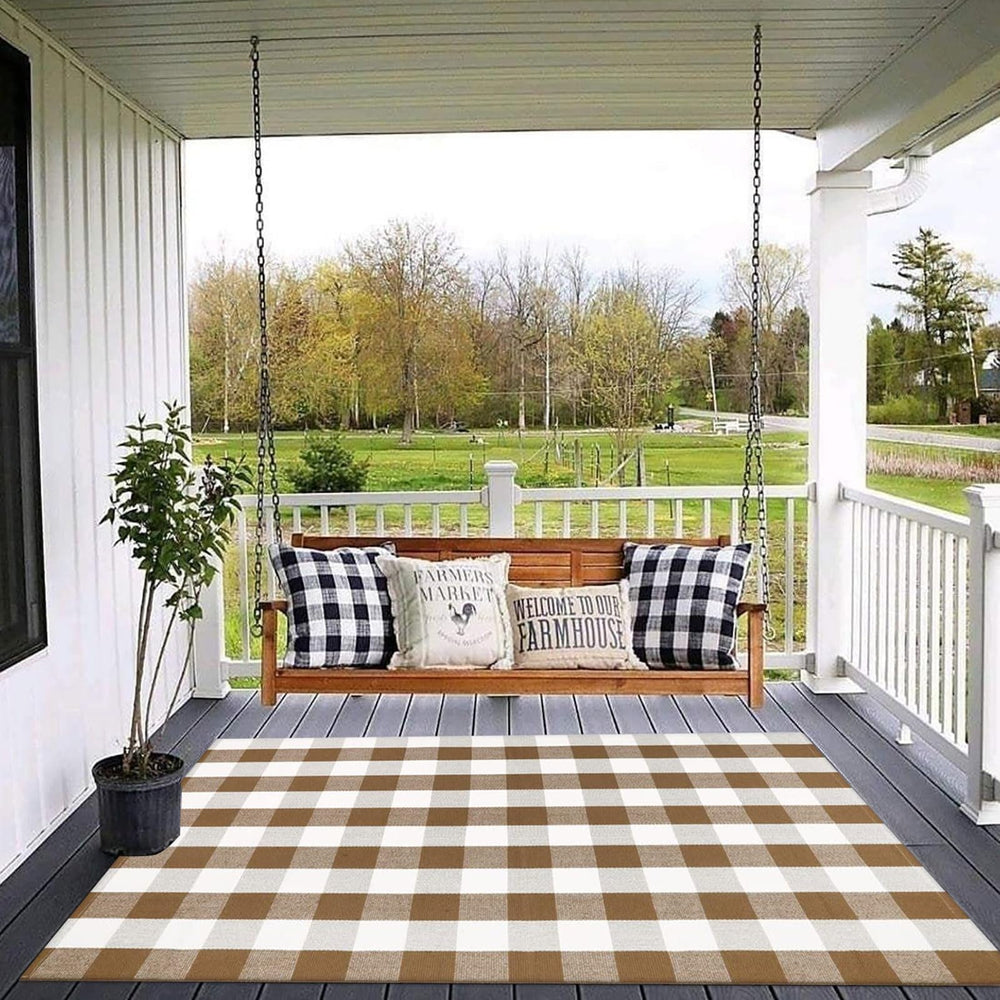 CAINANEL Buffalo Plaid Outdoor Rug layered with a welcome mat on a porch