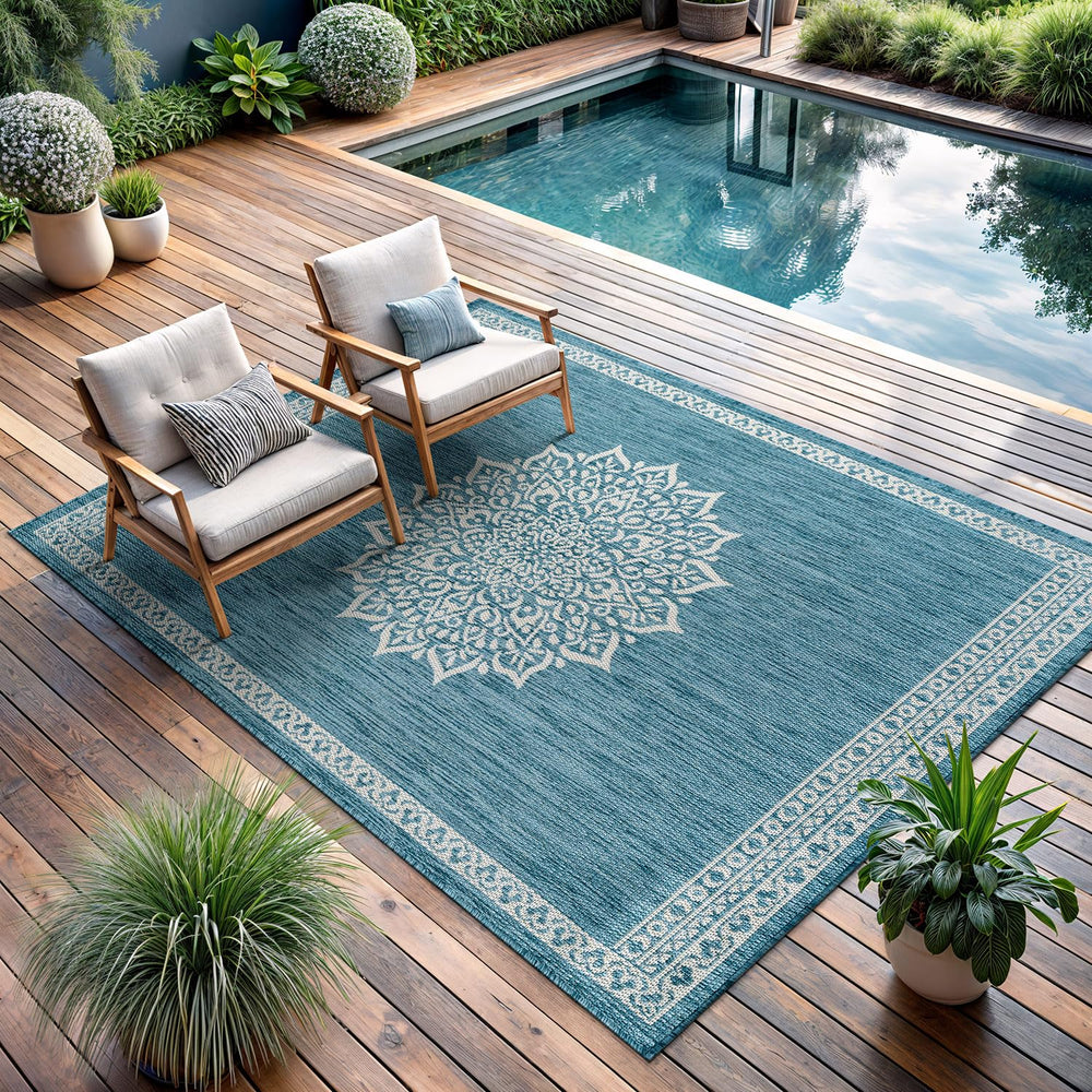 CAMILSON Outdoor Rug 6x9 Medallion Aqua being washed with a hose