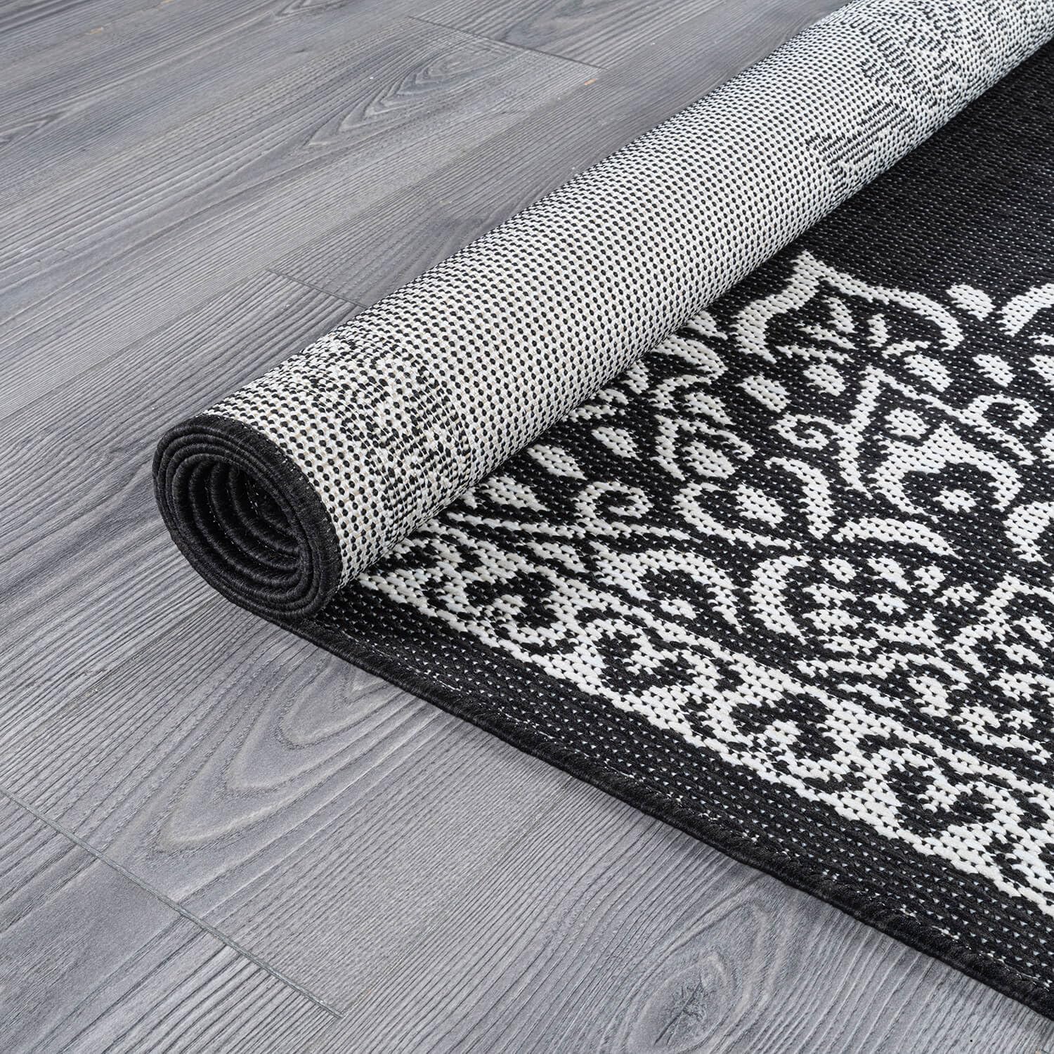 CAMILSON Outdoor Rug 6x9 Medallion Black rolled up