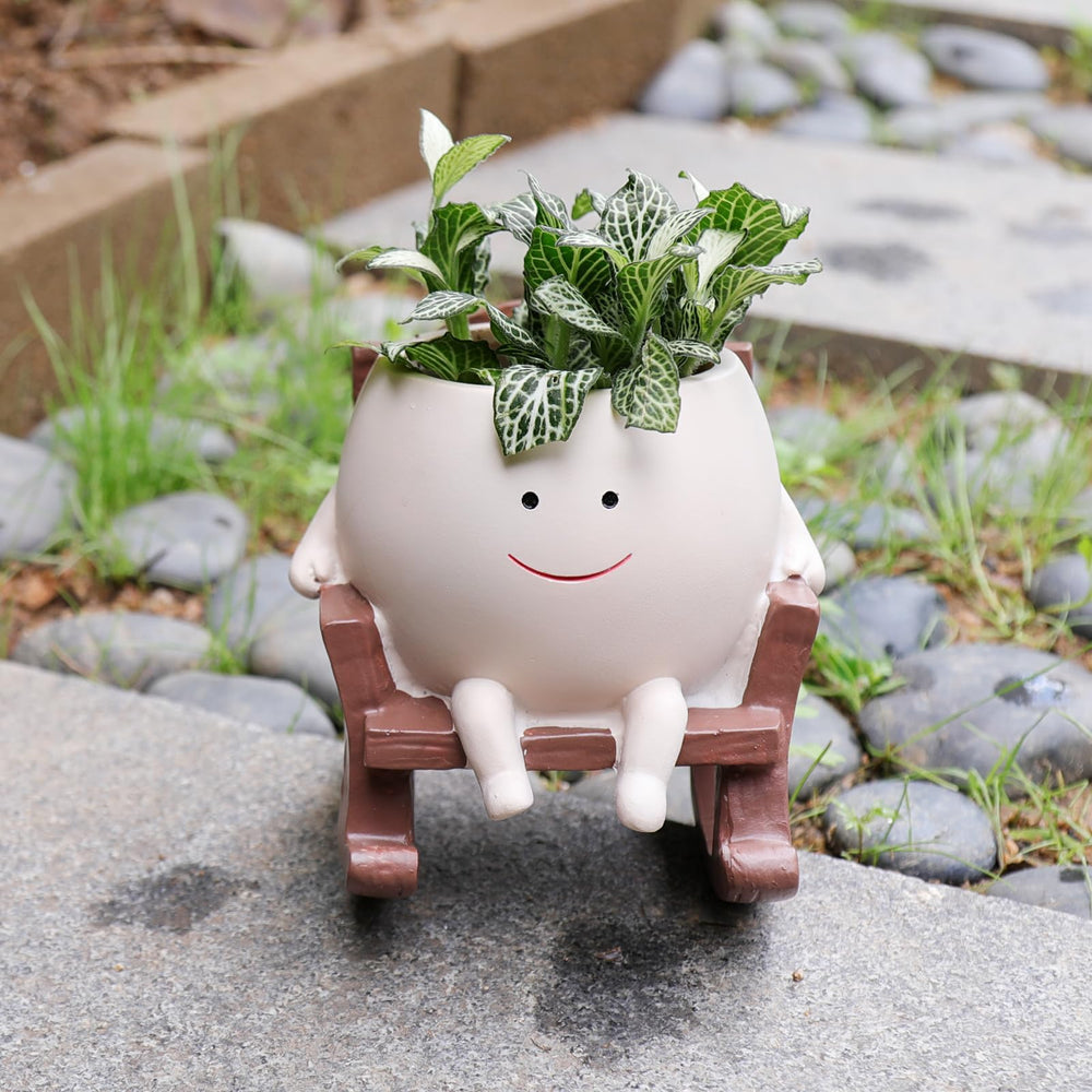 Camotank Smiley Face Rocking Chair Planter in a garden setting