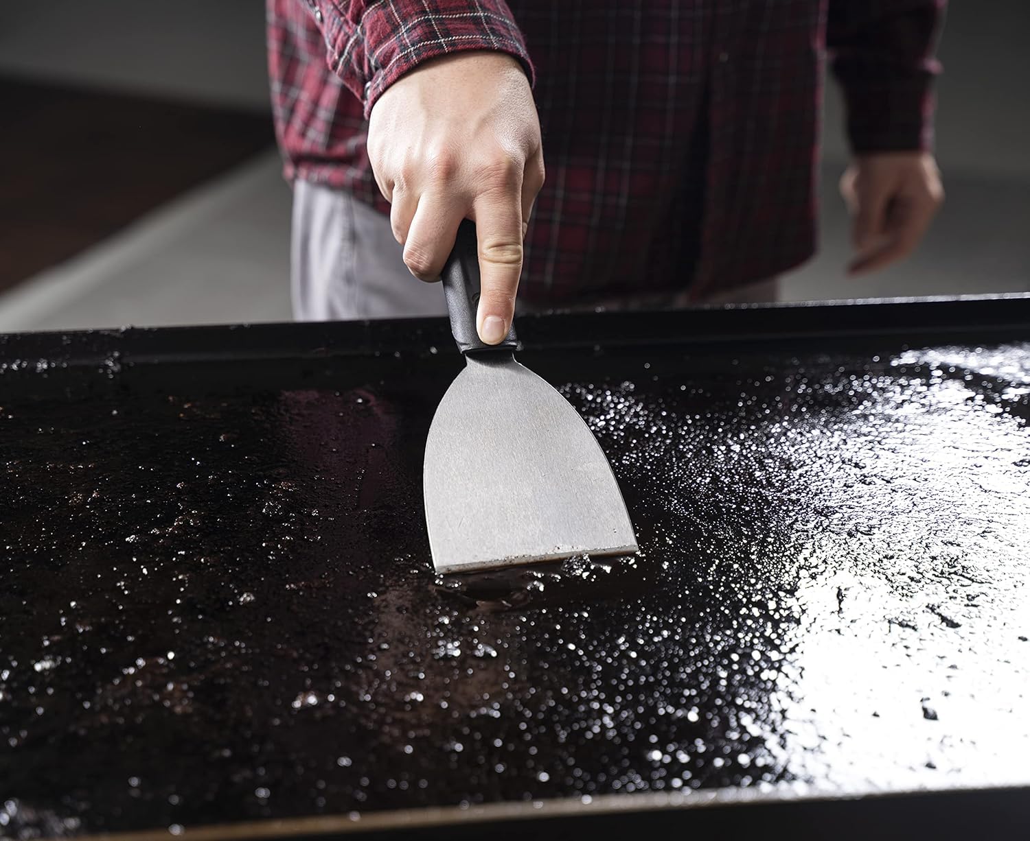 Close-up of BLACKSTONE stainless steel griddle scraper