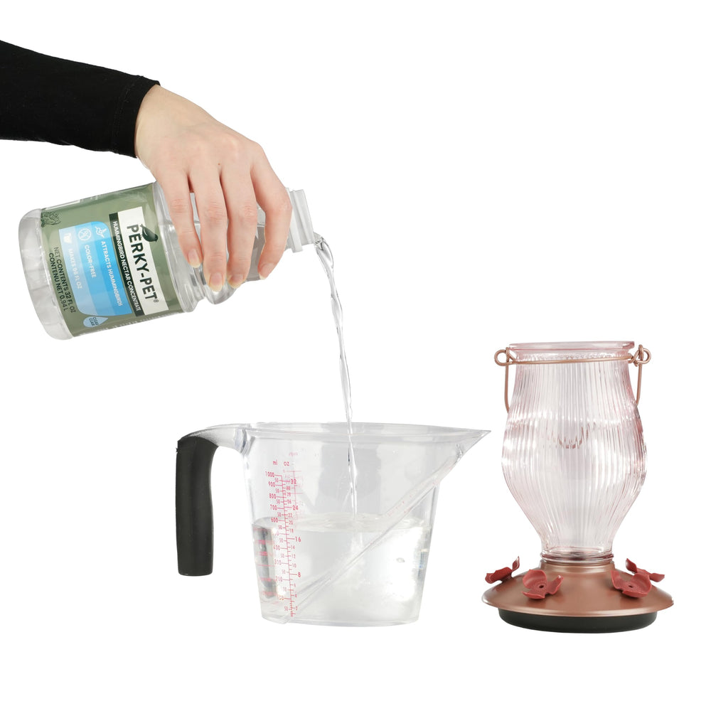 Close-up of Perky-Pet hummingbird nectar bottle with clear liquid