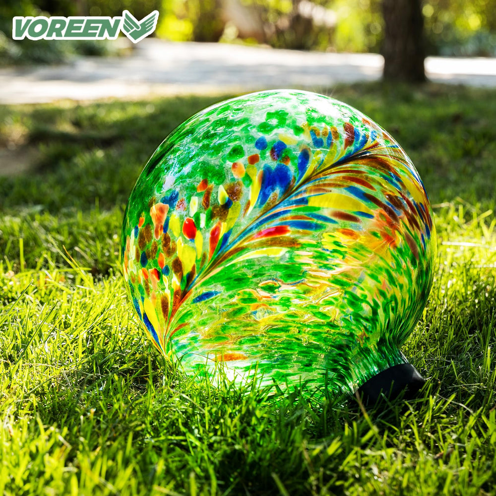 Close-up of VOREEN glass gazing ball's detailed phoenix tail pattern