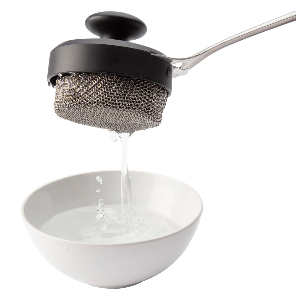 Cuisinart Chainmail Grill Cleaner being used on cast-iron cookware