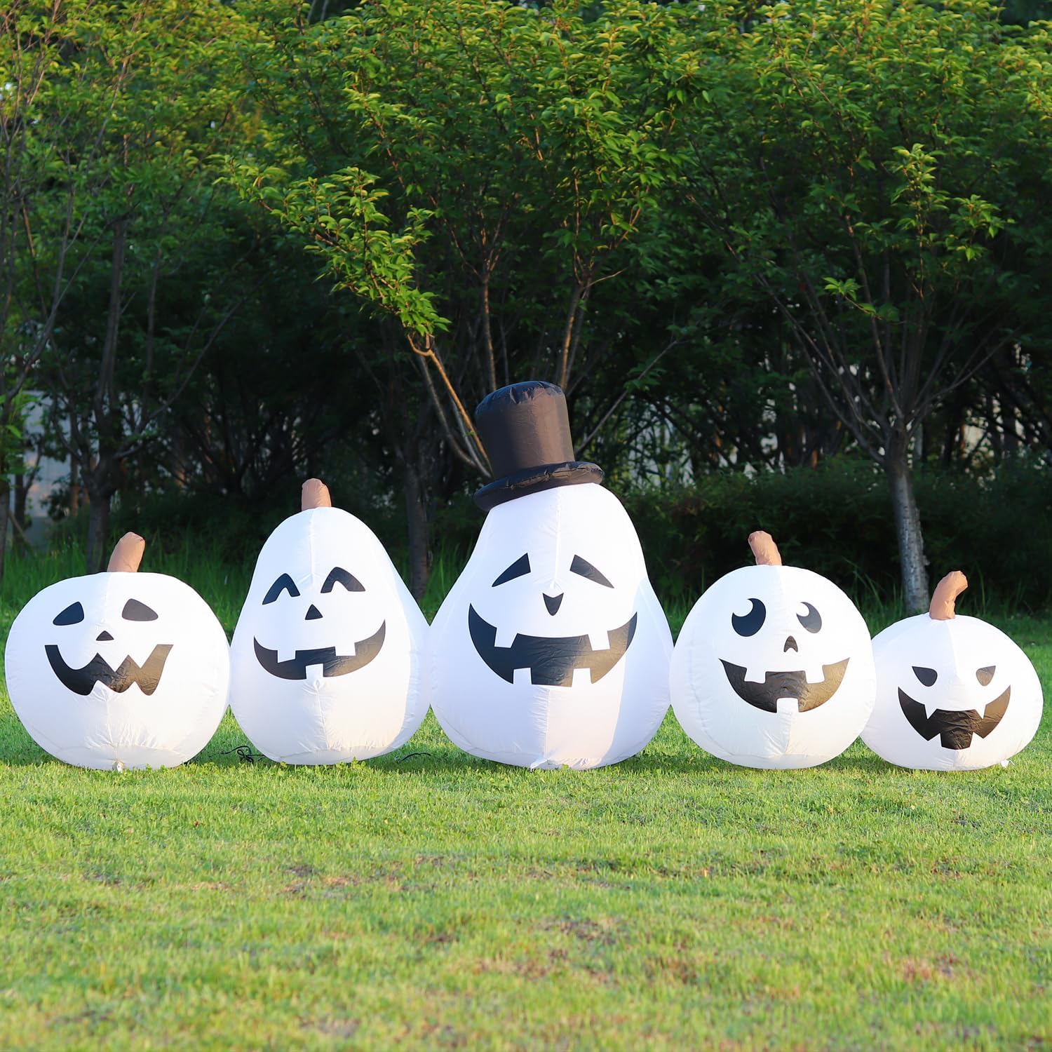 DomKom inflatable white pumpkin lit up at night in a garden setting