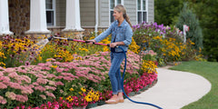 Dramm Rain Wand extended to full length in a garden setting