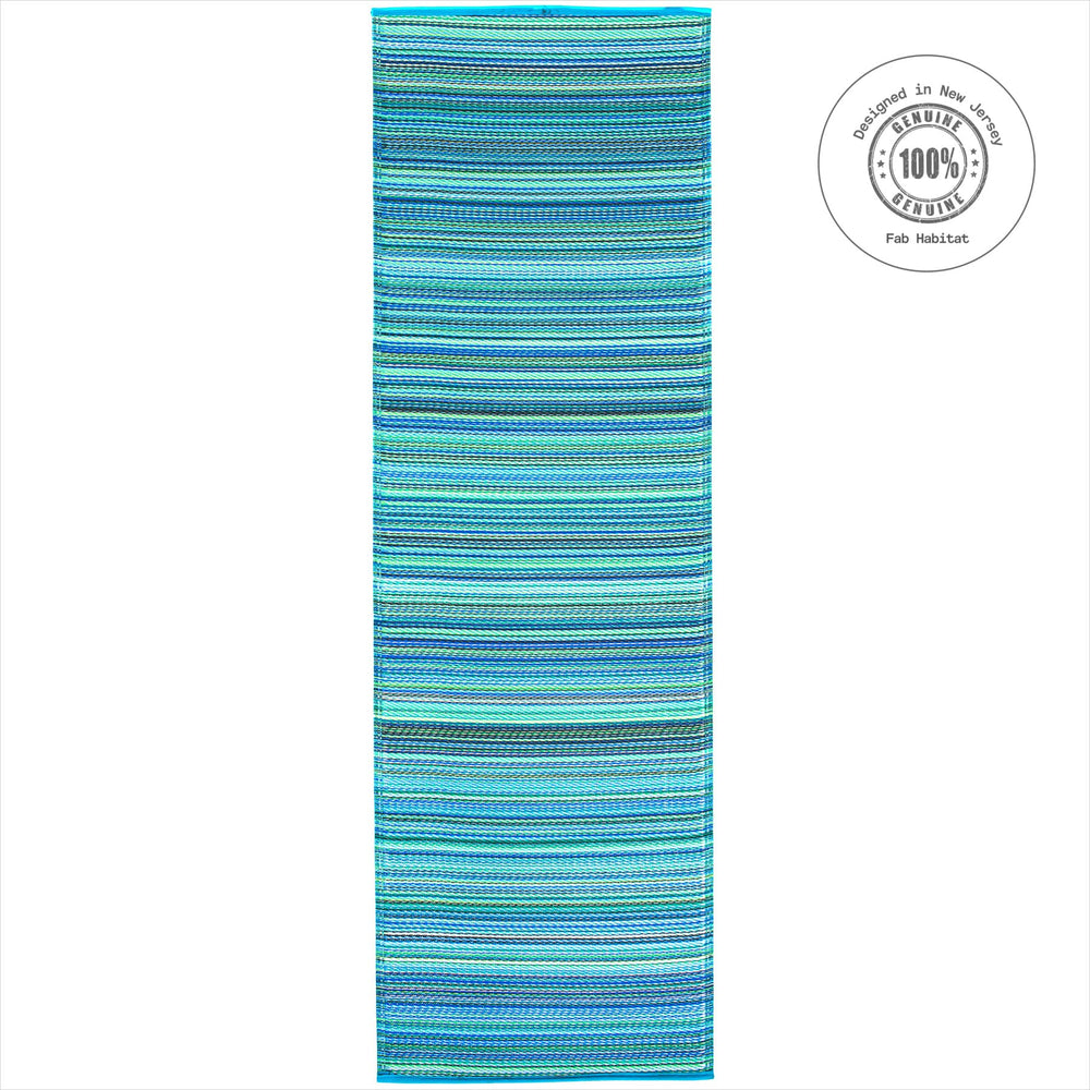 FAB HAB Outdoor Rug in turquoise and moss green on a patio