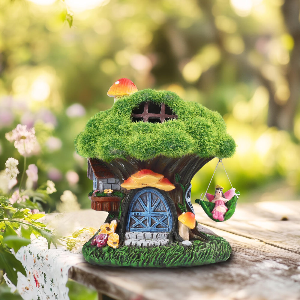 Fairy house statue next to potted plants on a patio