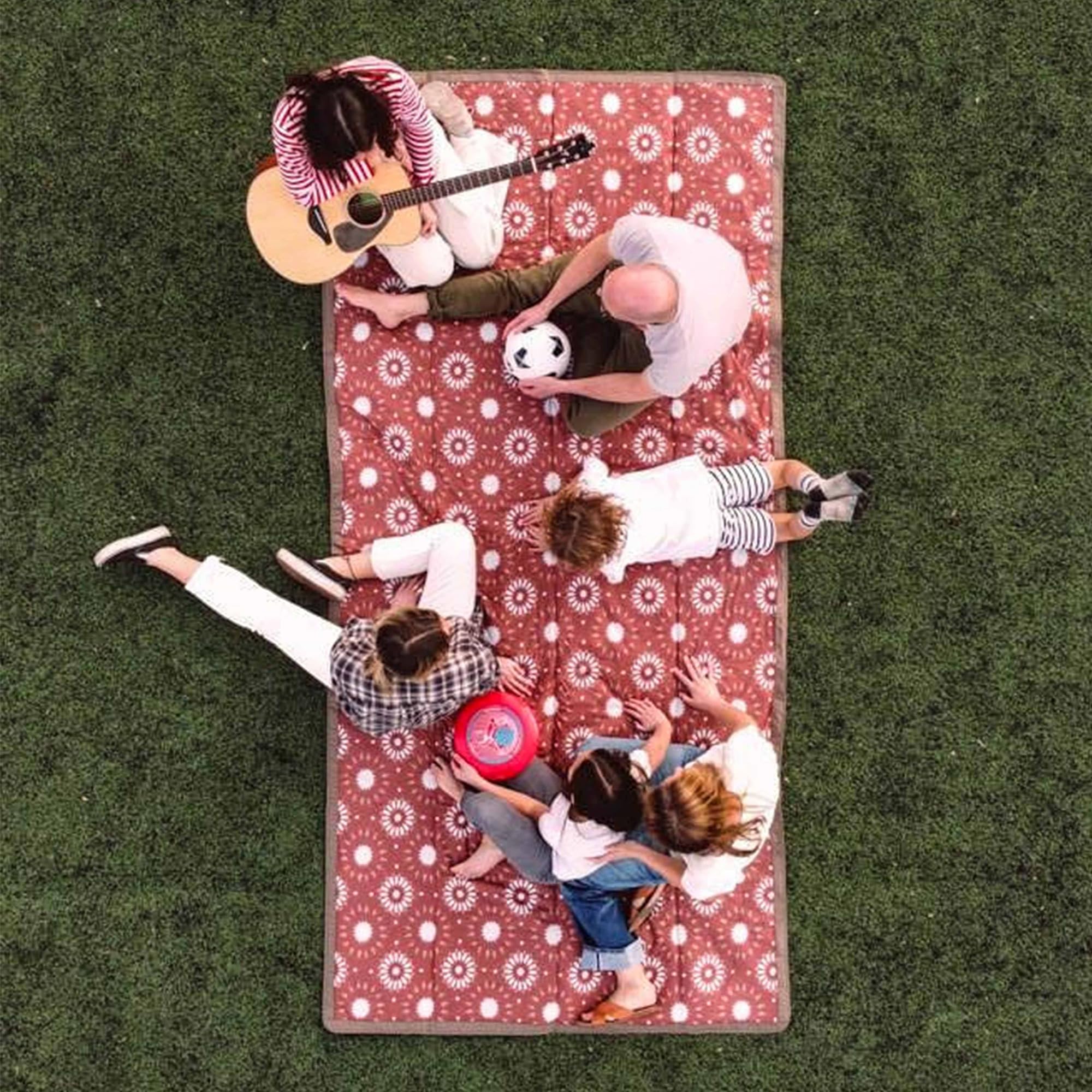 Family enjoying a picnic on the Little Unicorn blanket