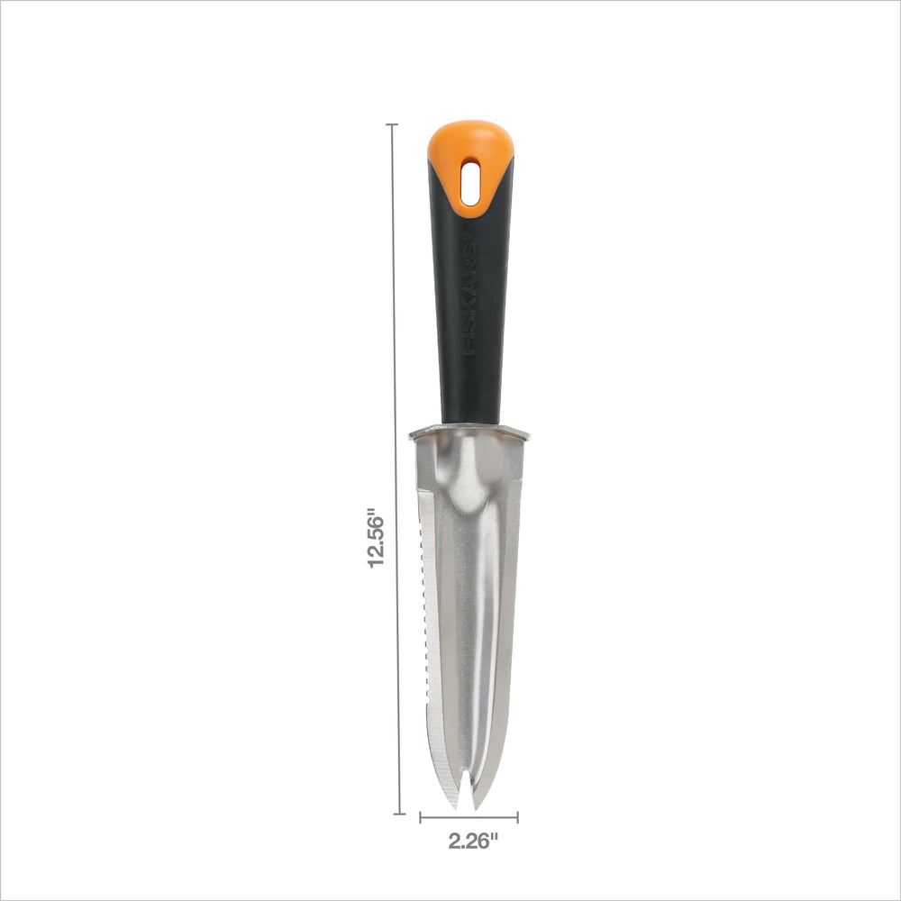 Fiskars garden knife resting on soil in a garden setting