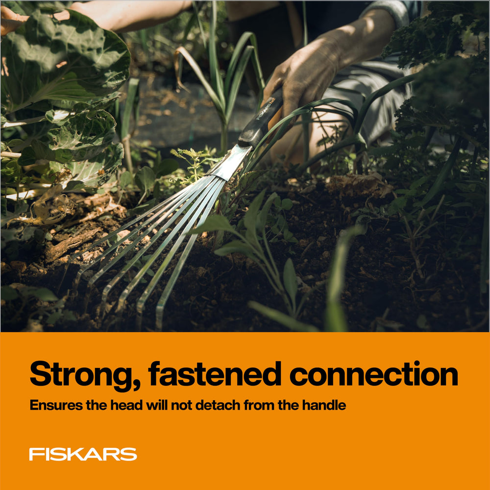 Fiskars Xact Hand Rake in a flowerbed for precise raking
