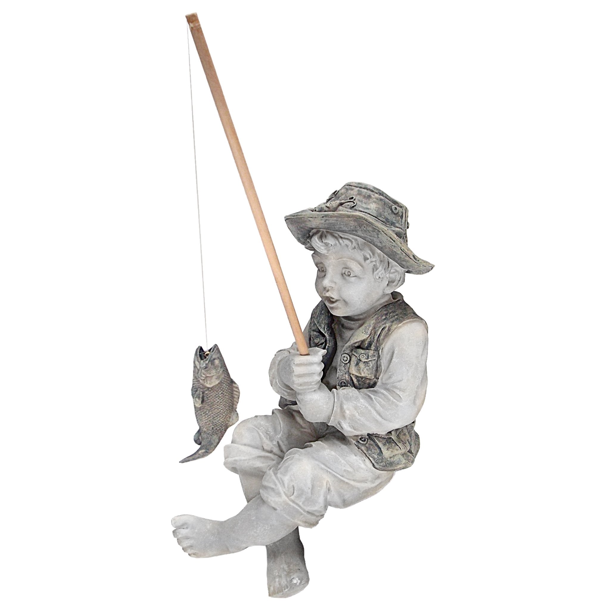 Frederic the Little Fisherman statue on a desk with decorative elements