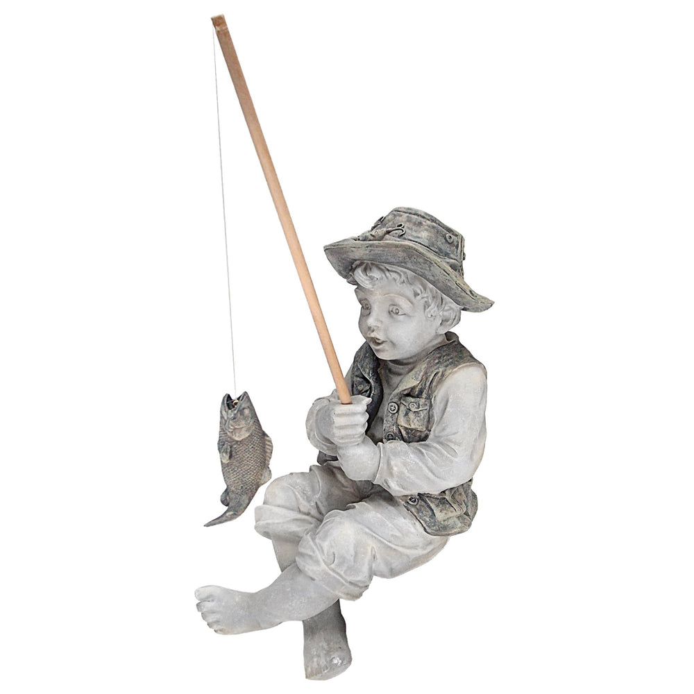 Frederic the Little Fisherman statue on a desk with decorative elements