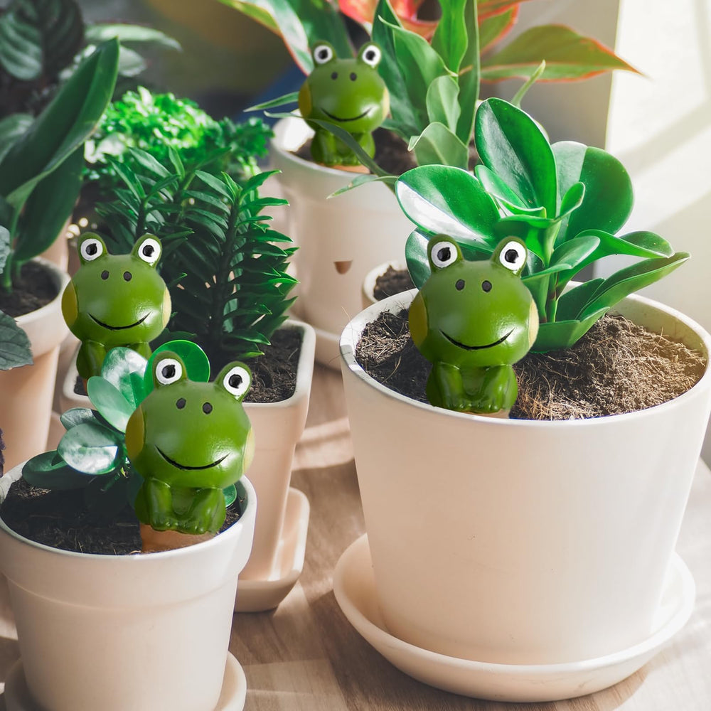 Frog shaped self watering spike inserted in a flower pot