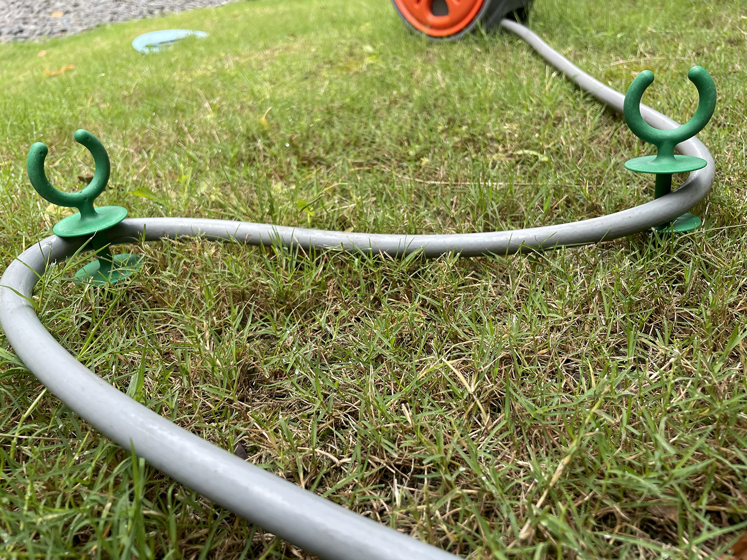 Garden hose guide stakes protecting plants