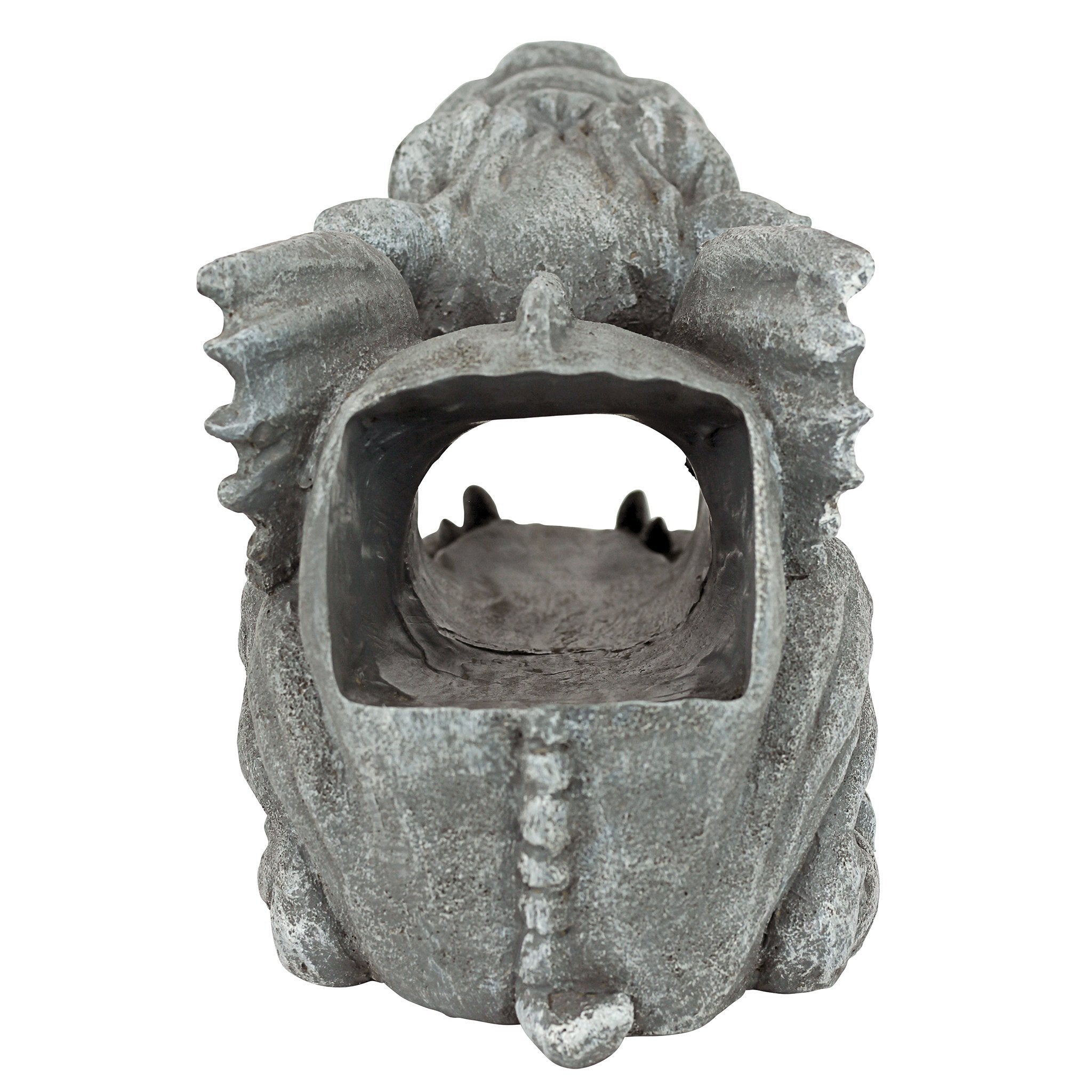 Gargoyle positioned on a downspout in a garden