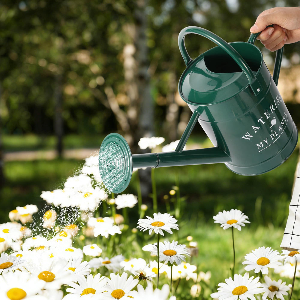 Garutom 1 Gallon Galvanized Watering Can green on a table with flowers