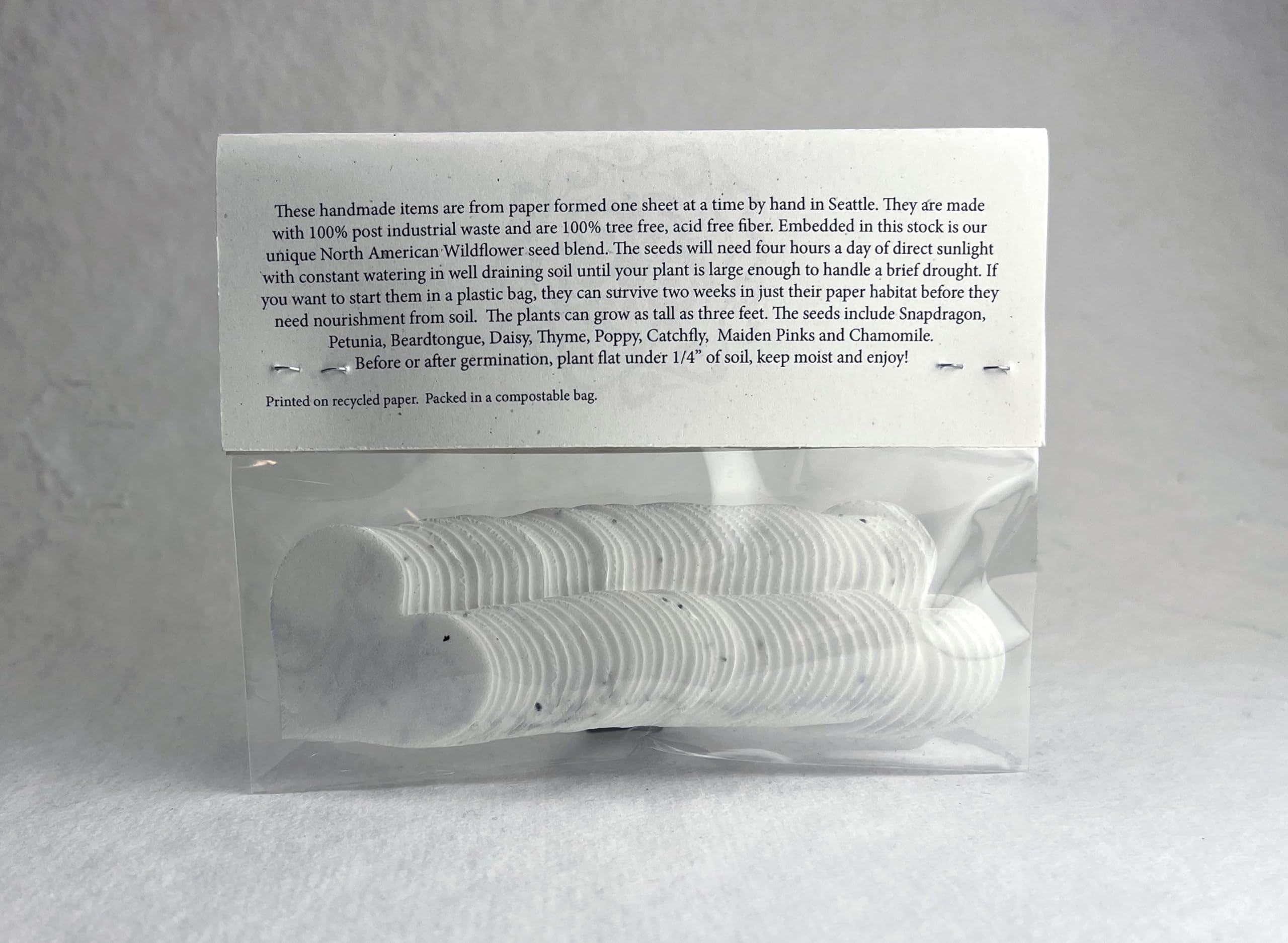 Heart-shaped seed paper tags with a rustic background