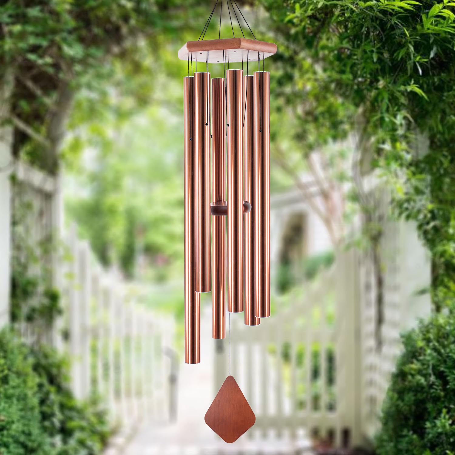 Howarmer wind chimes displayed on a porch with plants