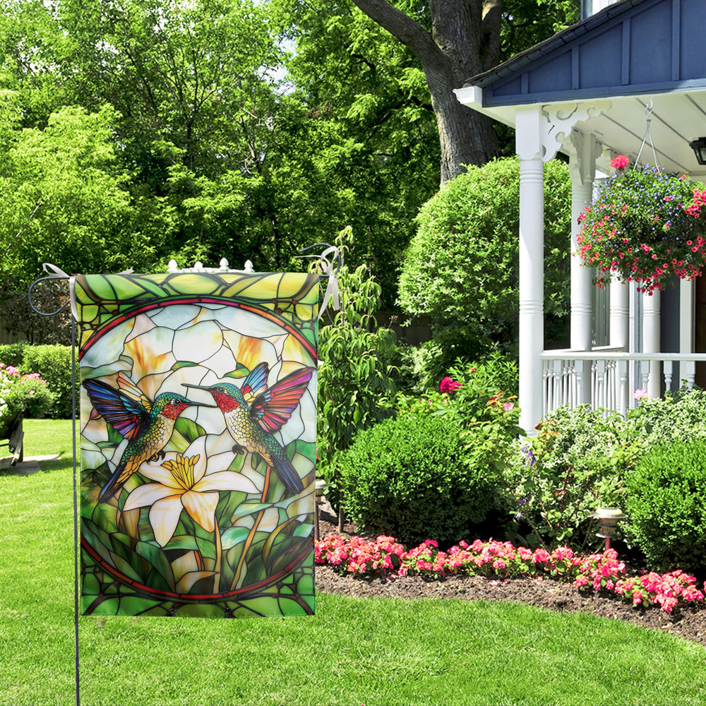 Hummingbird garden flag alongside beautiful flowers