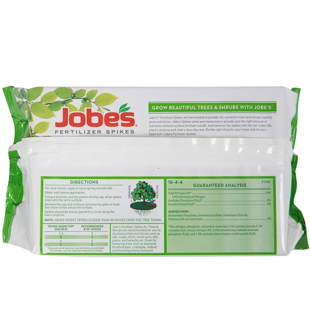 Jobe's fertilizer spikes being inserted into garden soil