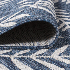 JONATHAN Y Palm Frond Round Area Rug in outdoor patio setting