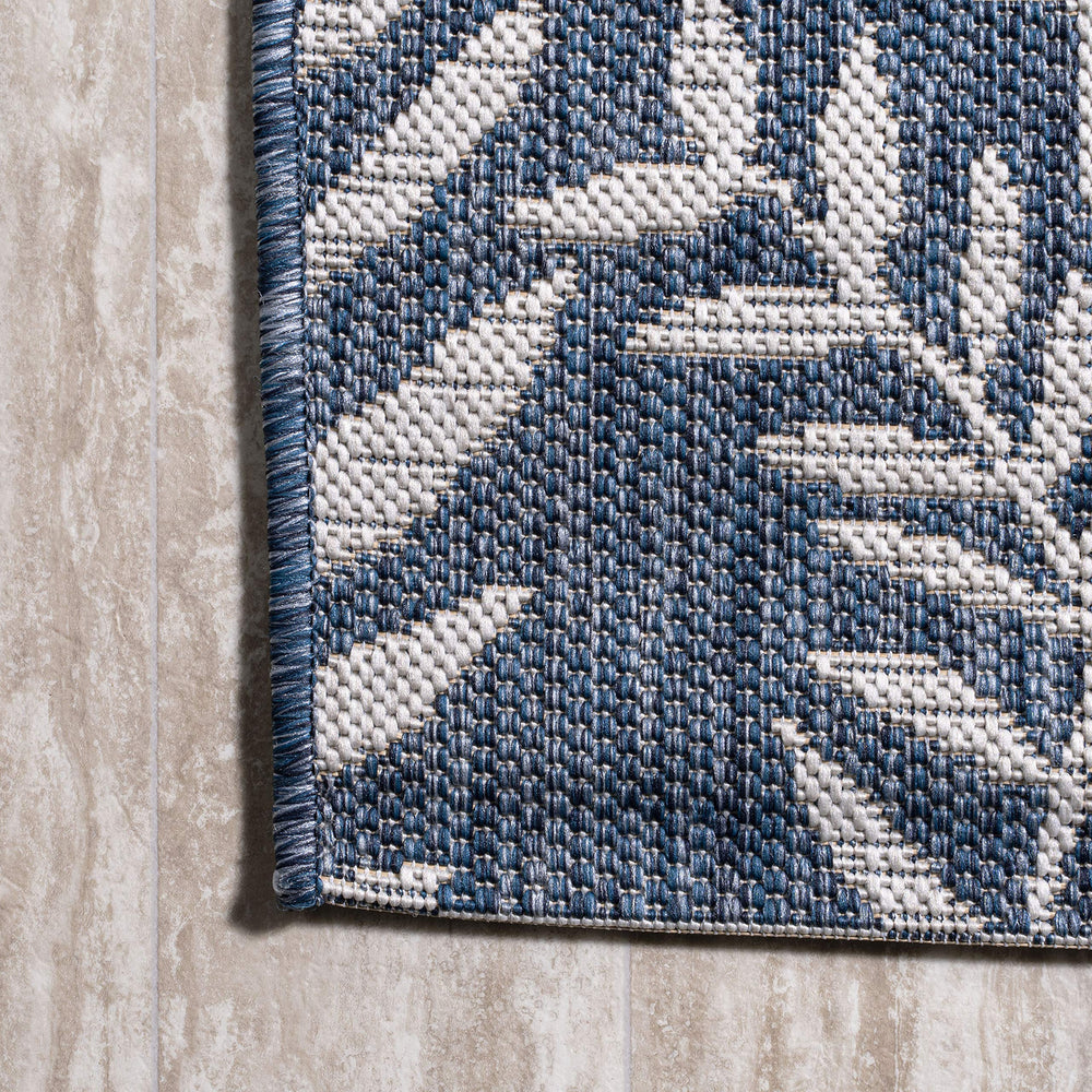 JONATHAN Y Palm Frond Round Area Rug rolled up for storage