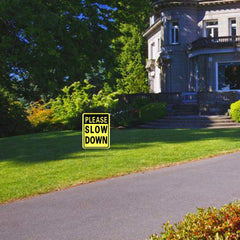 Kichwit Slow Down Yard Signs installed in yard with metal stakes