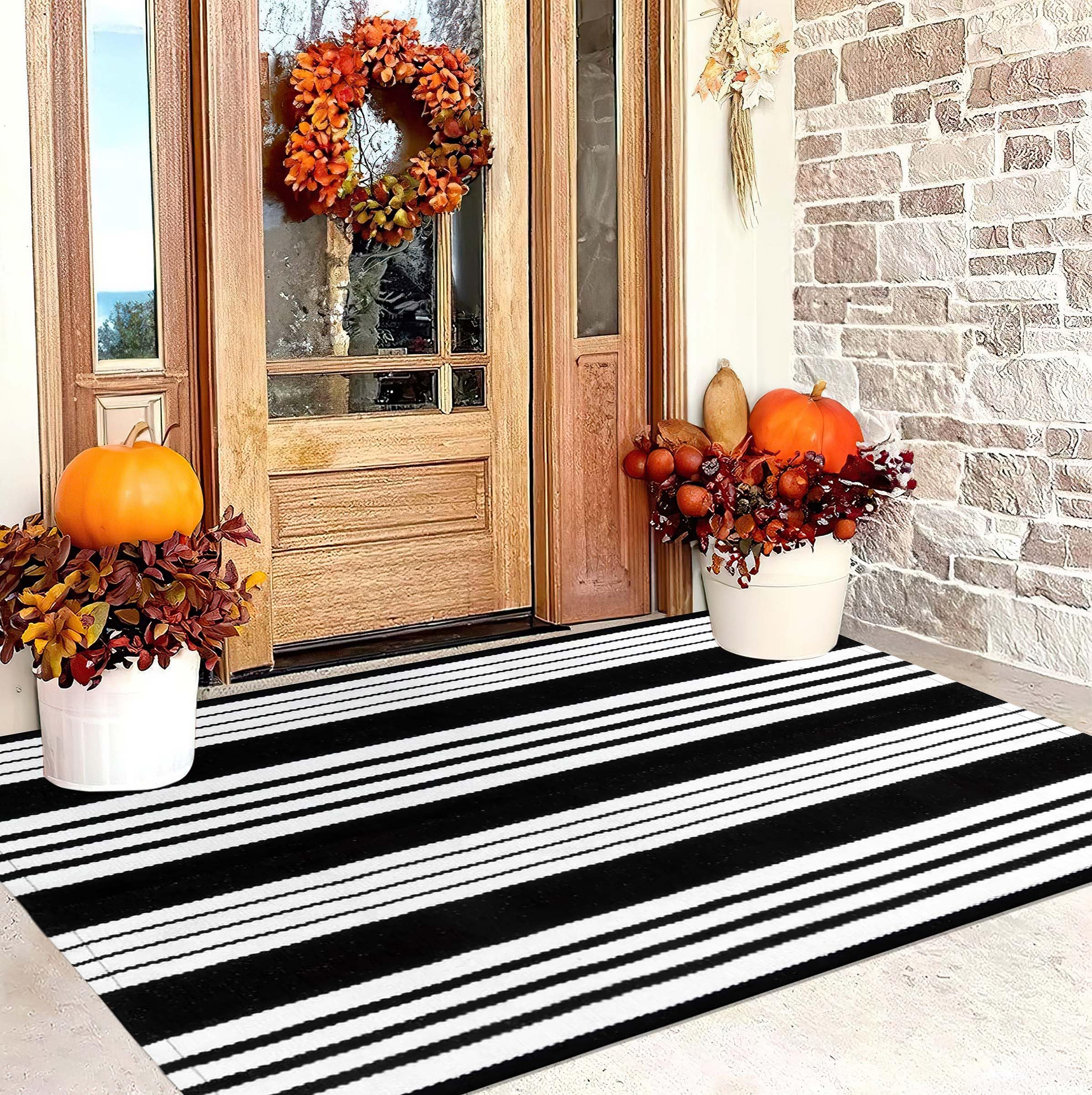 Layered view of BUAGETUP Black and White Outdoor Rug with welcome mat